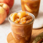 Glass jars filled with homemade Apple Pie Filling made from tender, spiced apple slices and syrupy cinnamon glaze.