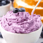 Creamy blueberry butter in a white bowl topped with fresh blueberries.