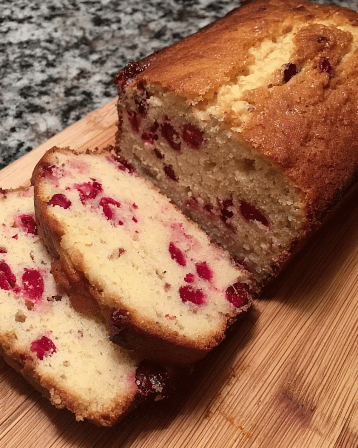 Sliced Cranberry Eggnog Bread on a wooden cutting board