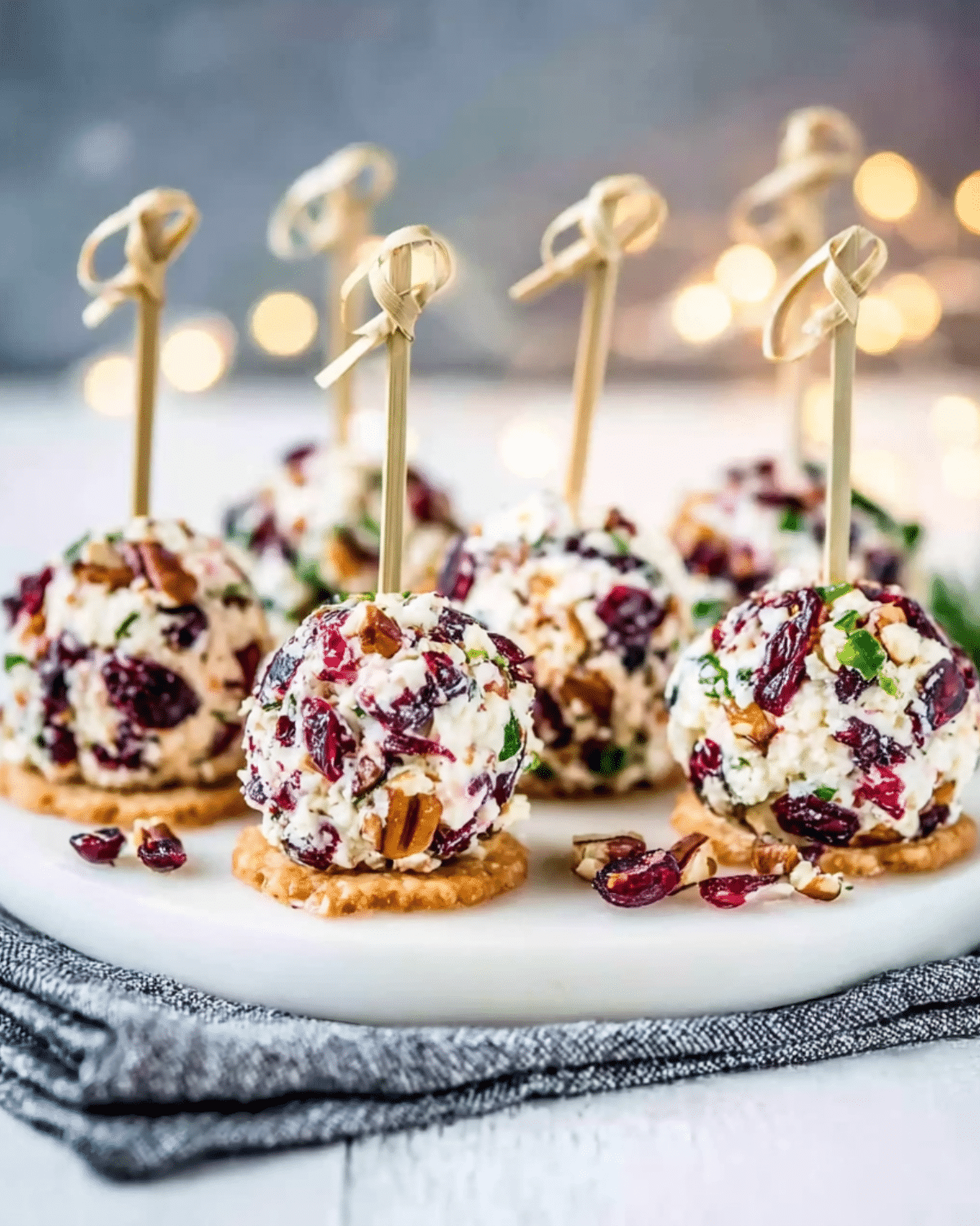 Mini Cranberry Pecan Cheese Balls on crackers with appetizer picks.