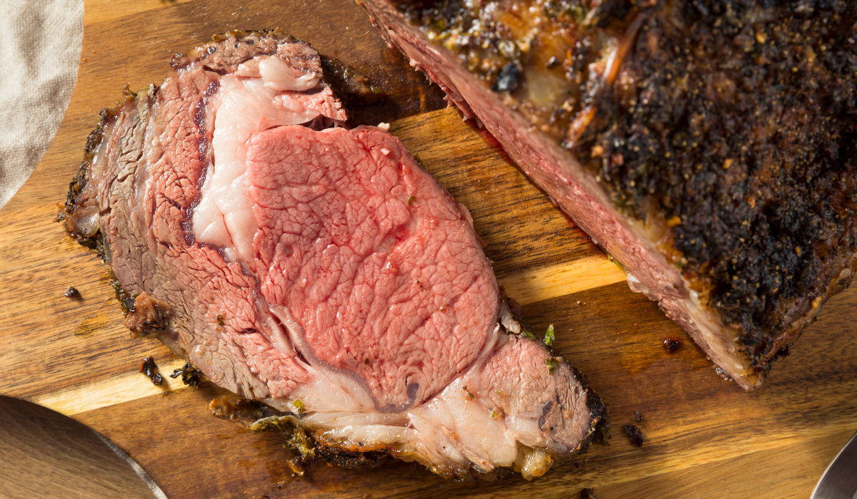 texas roadhouse prime rib recipesteak with a perfect pink center and a slightly charred exterior, garnished with fresh rosemary sprigs and a sprinkle of coarse salt, set in a warm and cozy kitchen background.
