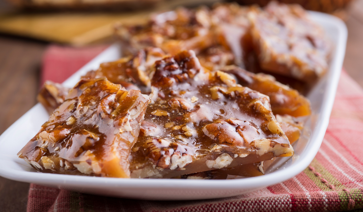 Plate of Microwave Peanut Brittle, a sweet caramel delight with crunchy nuts.