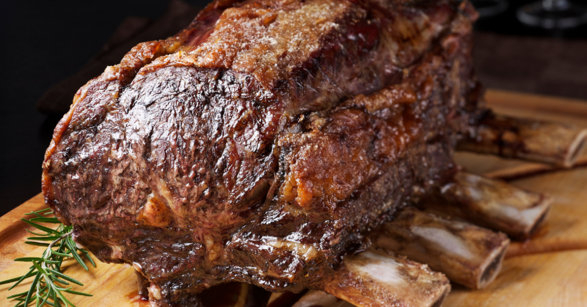 searing prime rib roast on a wooden cutting board