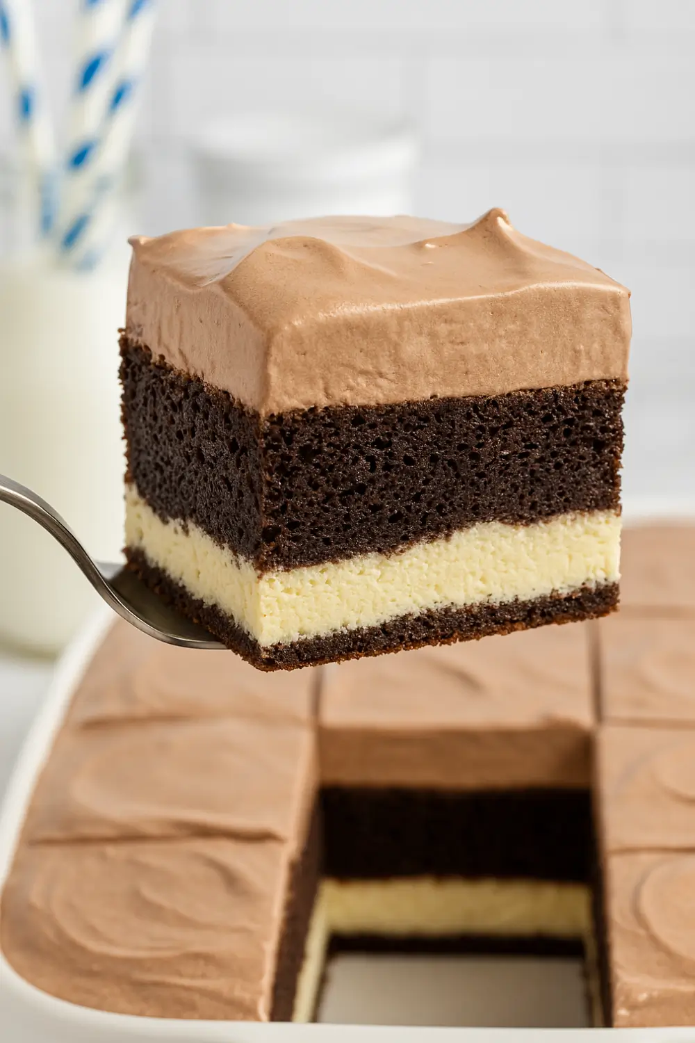 A slice of Italian Love Cake with layers of chocolate cake, ricotta filling, and whipped chocolate pudding topping.