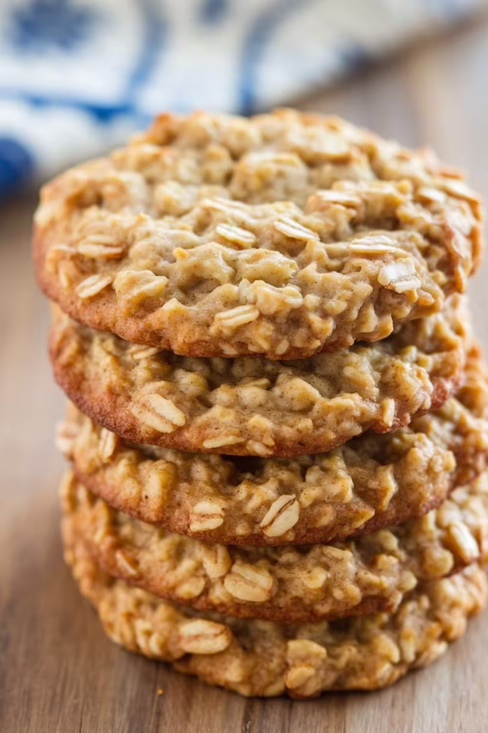 Stack of soft and chewy oatmeal cookies on a wooden surface.