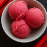 Bowl of vibrant pink rhubarb ice cream scoops