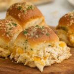 Cheesy Crack Chicken Sliders filled with shredded chicken, bacon, and melted cheese on buttery rolls, topped with parsley.