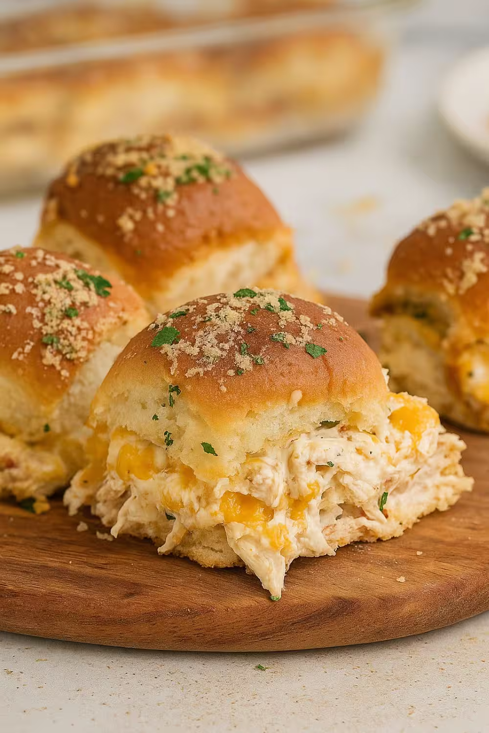 Cheesy Crack Chicken Sliders filled with shredded chicken, bacon, and melted cheese on buttery rolls, topped with parsley.