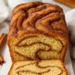 Close-up of a sliced loaf of Amish Cinnamon Bread with a beautifully swirled cinnamon-sugar filling.