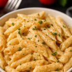 Creamy Cajun Chicken Pasta served in a white bowl, topped with fresh parsley and a light sprinkle of Cajun seasoning.