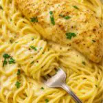 Creamy and tender chicken served over a bed of angel hair pasta, garnished with fresh parsley.