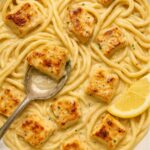 Creamy Cowboy Butter Chicken Linguine garnished with lemon, served in a white bowl.