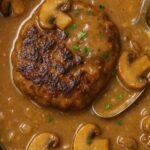 Salisbury Steak with Mushroom Gravy with rich mushroom gravy in a cast iron skillet.