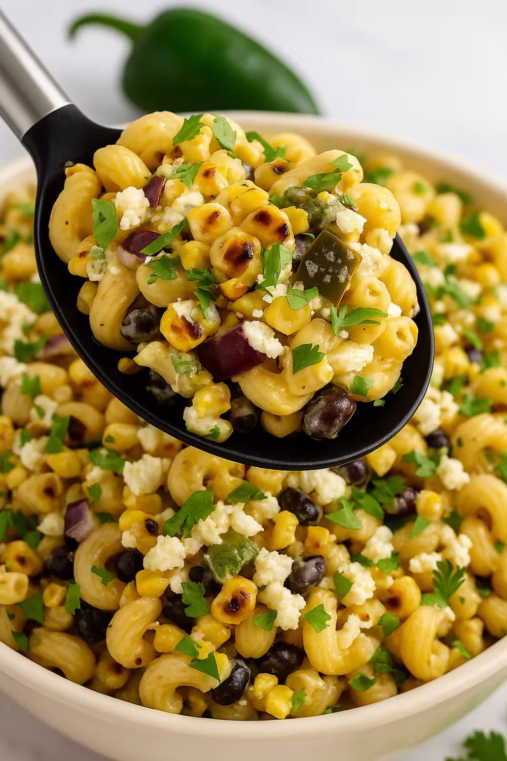 Mexican Street Corn Pasta Salad with grilled corn, black beans, cotija cheese, and fresh cilantro served in a bowl.