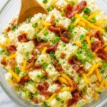 Loaded Baked Potato Salad with crispy bacon, cheddar cheese, and green onions in a creamy dressing.