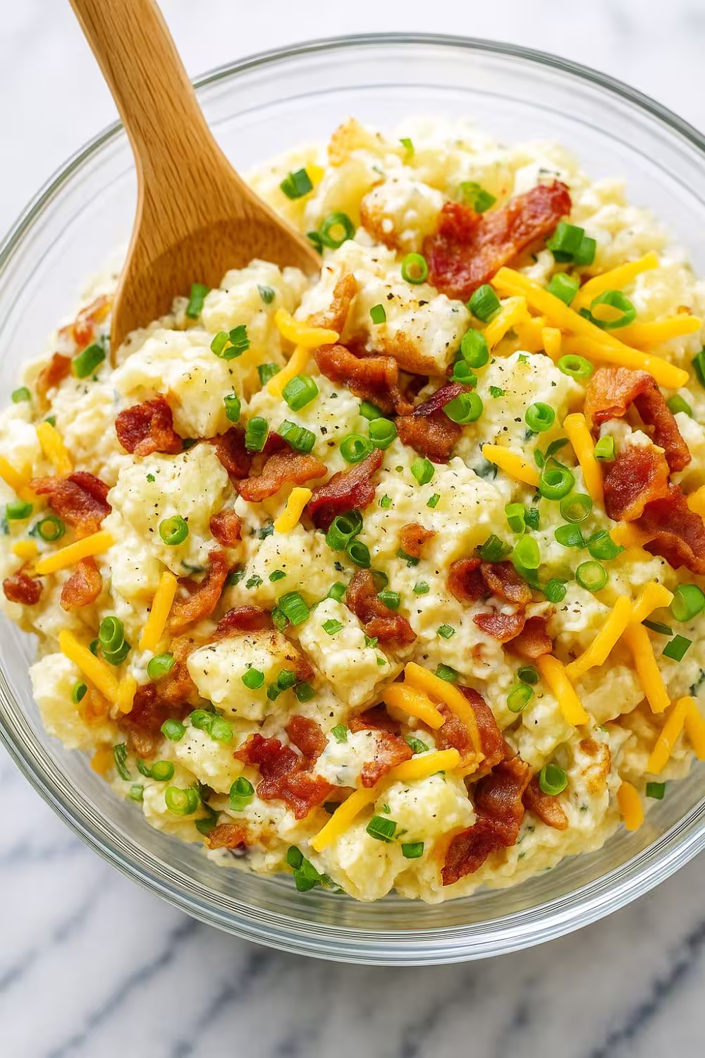 Loaded Baked Potato Salad with crispy bacon, cheddar cheese, and green onions in a creamy dressing.