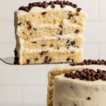 Close-up of a slice of Easy Cannoli Cake layered with creamy ricotta filling and chocolate chips.