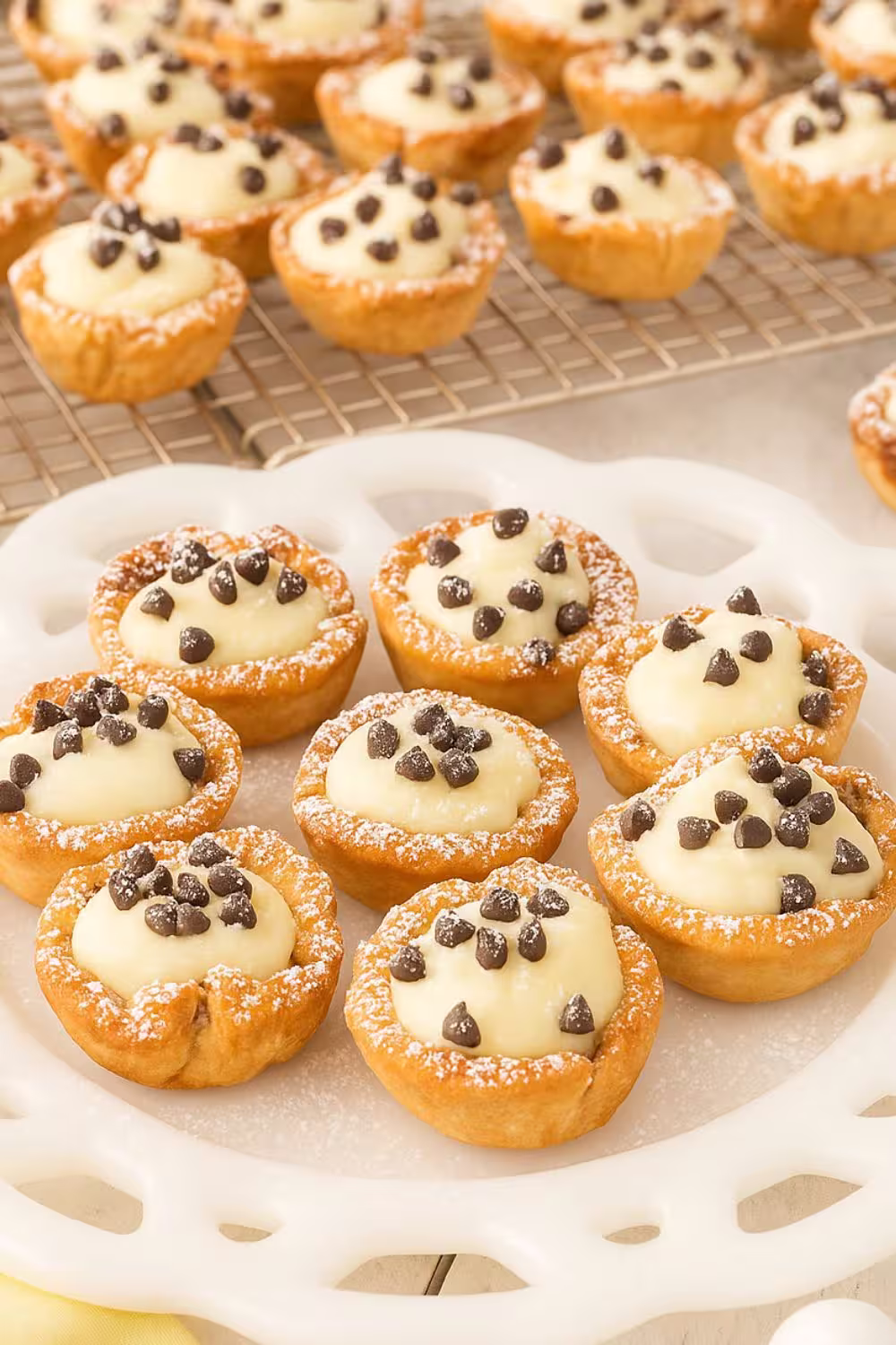 Bite-sized Mini Cannoli Cups filled with sweet ricotta cream and chocolate chips, served on a decorative white plate.