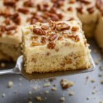 Moist Italian cream sheet cake topped with cream cheese frosting and chopped pecans.