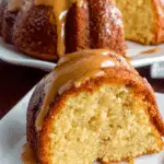 A moist slice of Black People’s Pound Cake topped with rich caramel glaze, served on a white plate.