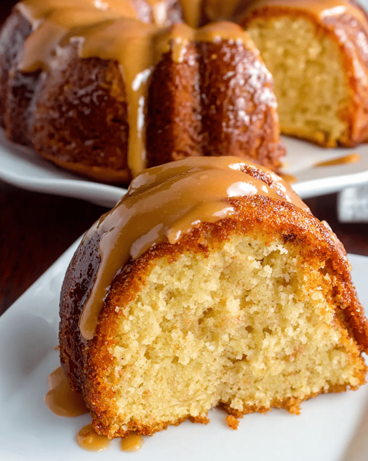 A moist slice of Black People’s Pound Cake topped with rich caramel glaze, served on a white plate.