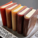 Fruit Leather Books made from colorful fruit roll-ups wrapped around white filling to resemble miniature books on a decorative silver tray.