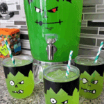 Frankenstein Green Punch served in themed glasses and a large Frankenstein drink dispenser with green liquid and straws.