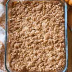 Pumpkin crisp in a glass baking dish with a golden brown oat crumble topping.
