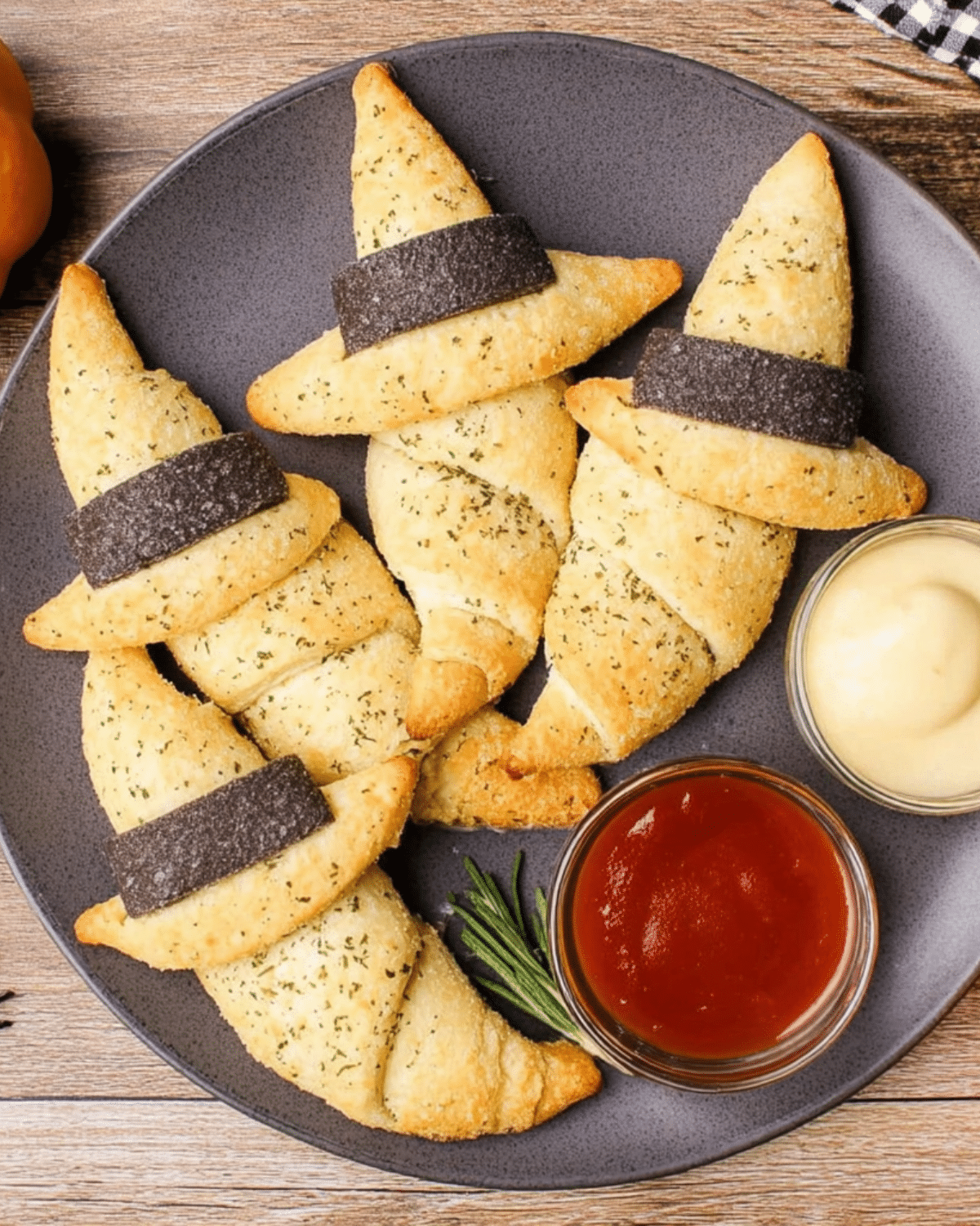 Witch hat crescent rolls topped with black edible bands, served with ketchup and mustard dipping sauces.