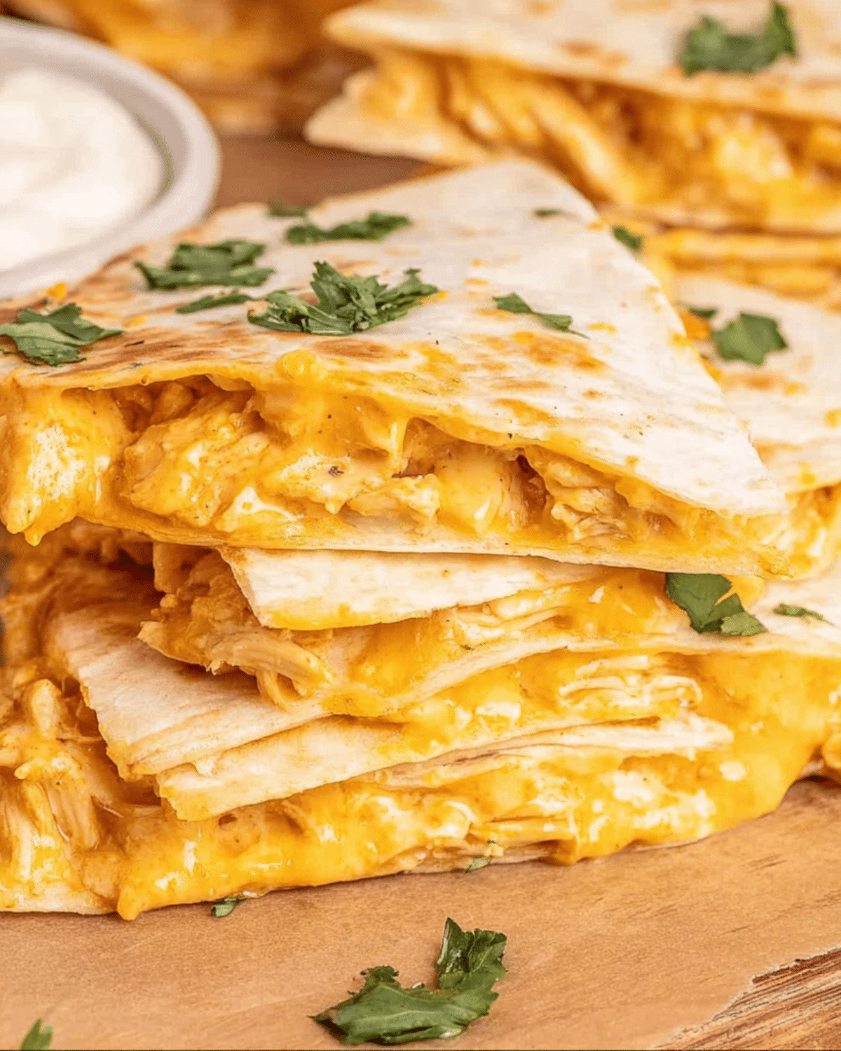 Stack of crispy Air Fryer Buffalo Chicken Quesadillas filled with melted cheese and shredded chicken, garnished with cilantro.