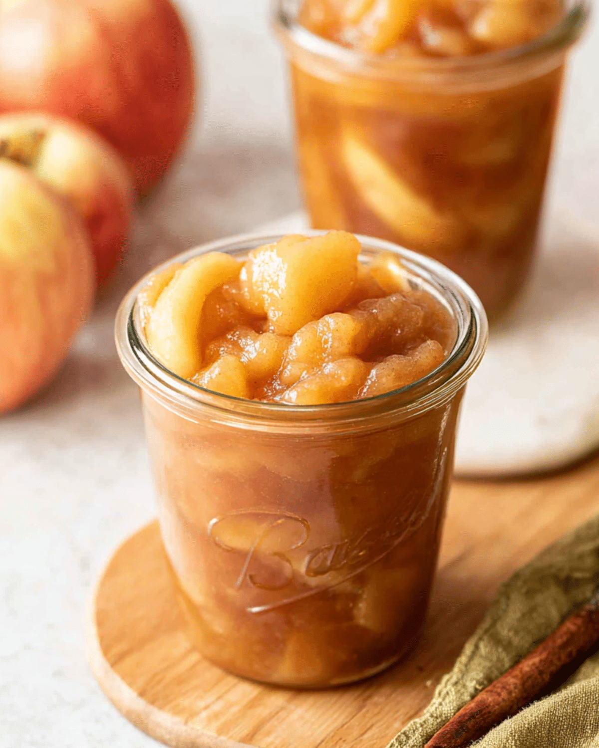 Glass jars filled with homemade Apple Pie Filling made from tender, spiced apple slices and syrupy cinnamon glaze.