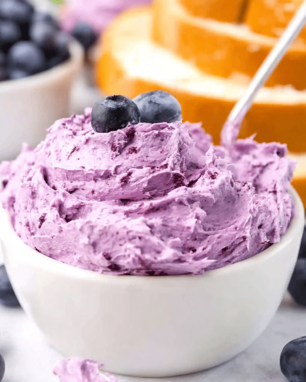Creamy blueberry butter in a white bowl topped with fresh blueberries.