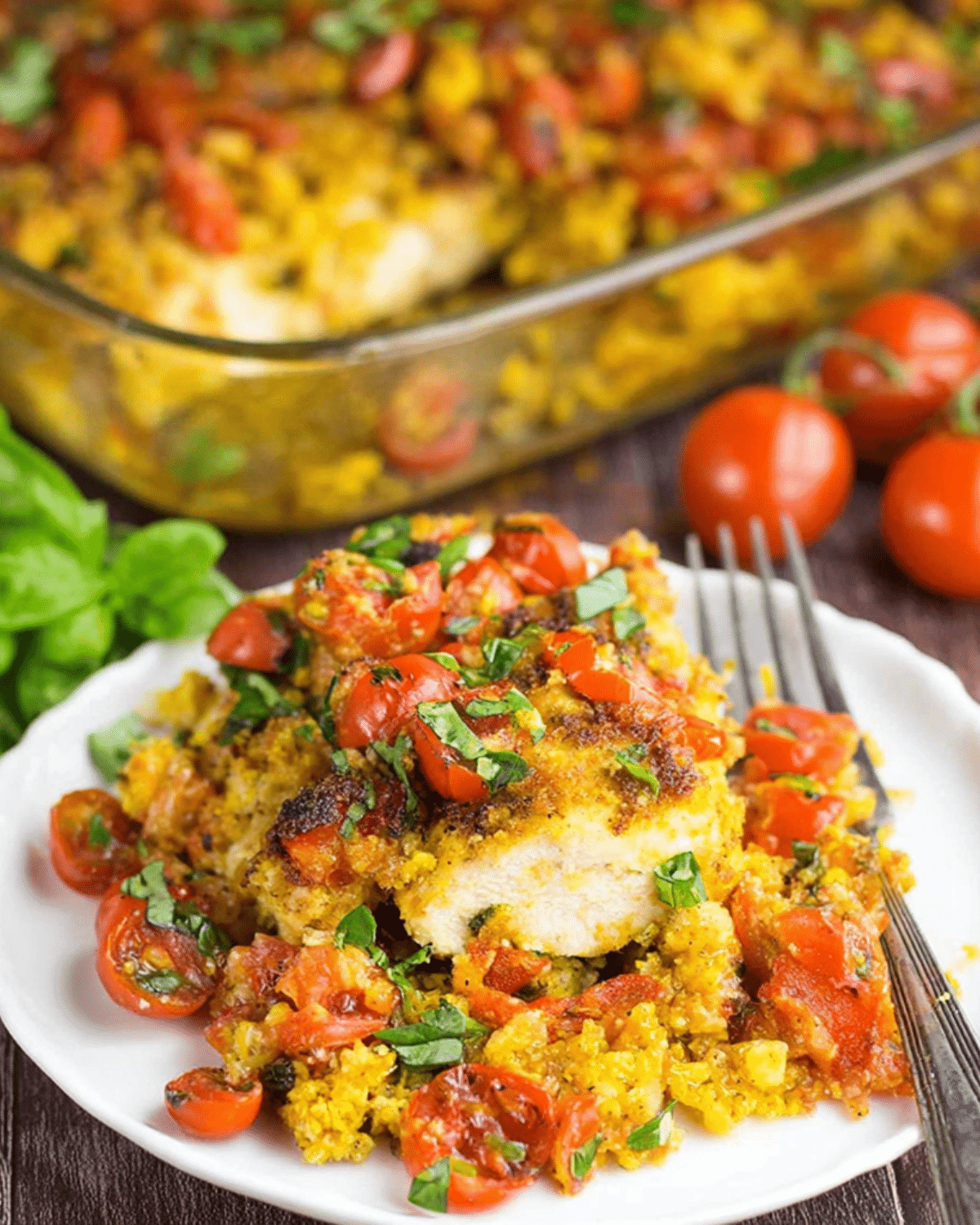 Plate of bruschetta chicken bake topped with roasted cherry tomatoes, herbs, and crispy golden breadcrumbs.