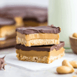Stack of Buckeye Bars with layers of chocolate, creamy peanut butter filling, and a cookie-like base.