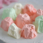 Colorful pieces of Jello Divinity Candy in pastel pink, green, and white arranged on a white plate.