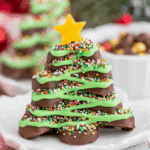A festive Reese's Candy Christmas Tree made from stacked chocolate peanut butter cups, decorated with green icing, colorful sprinkles, and a yellow candy star on top.