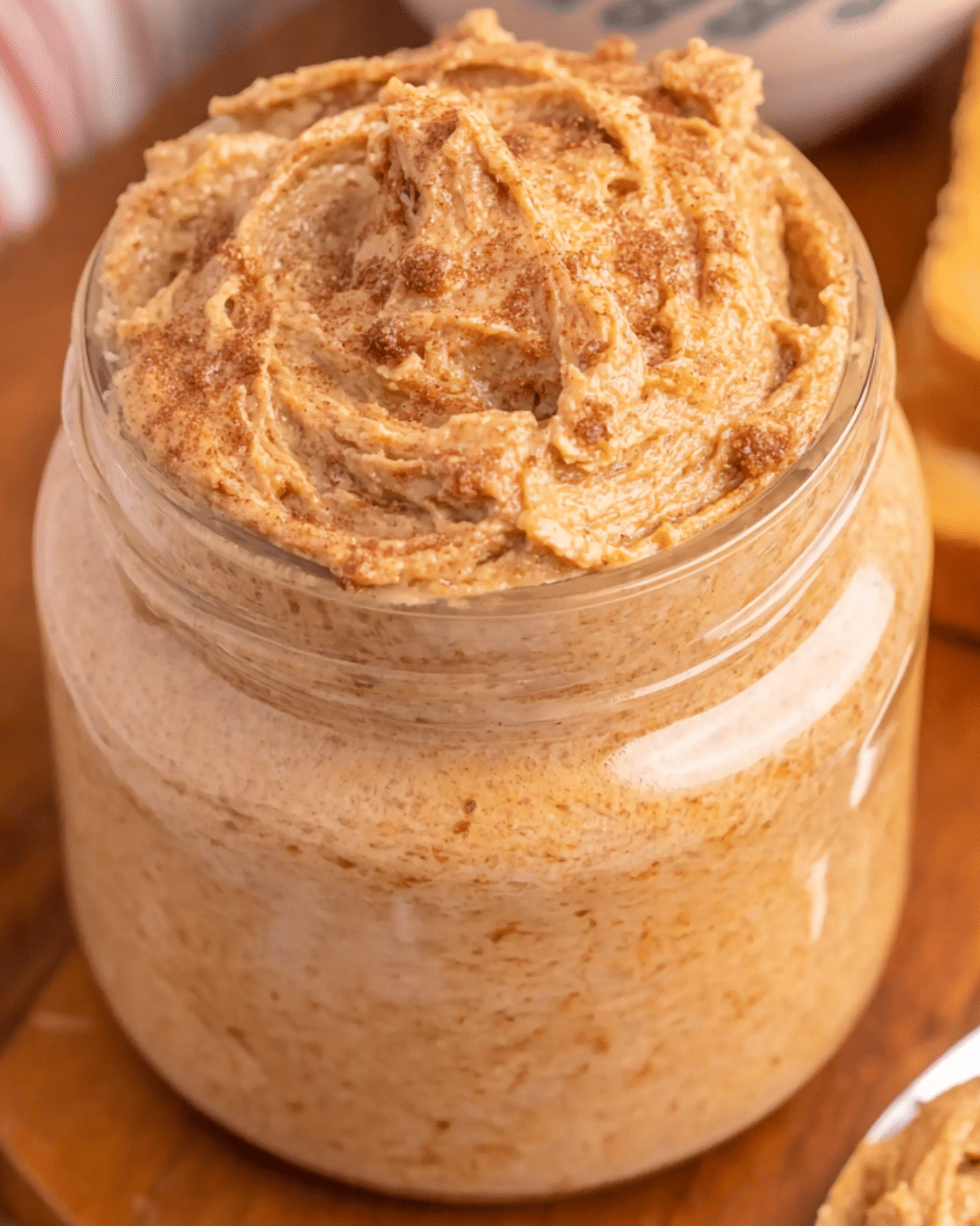 Jar of creamy brown sugar cinnamon butter, swirled on top and sprinkled with cinnamon.