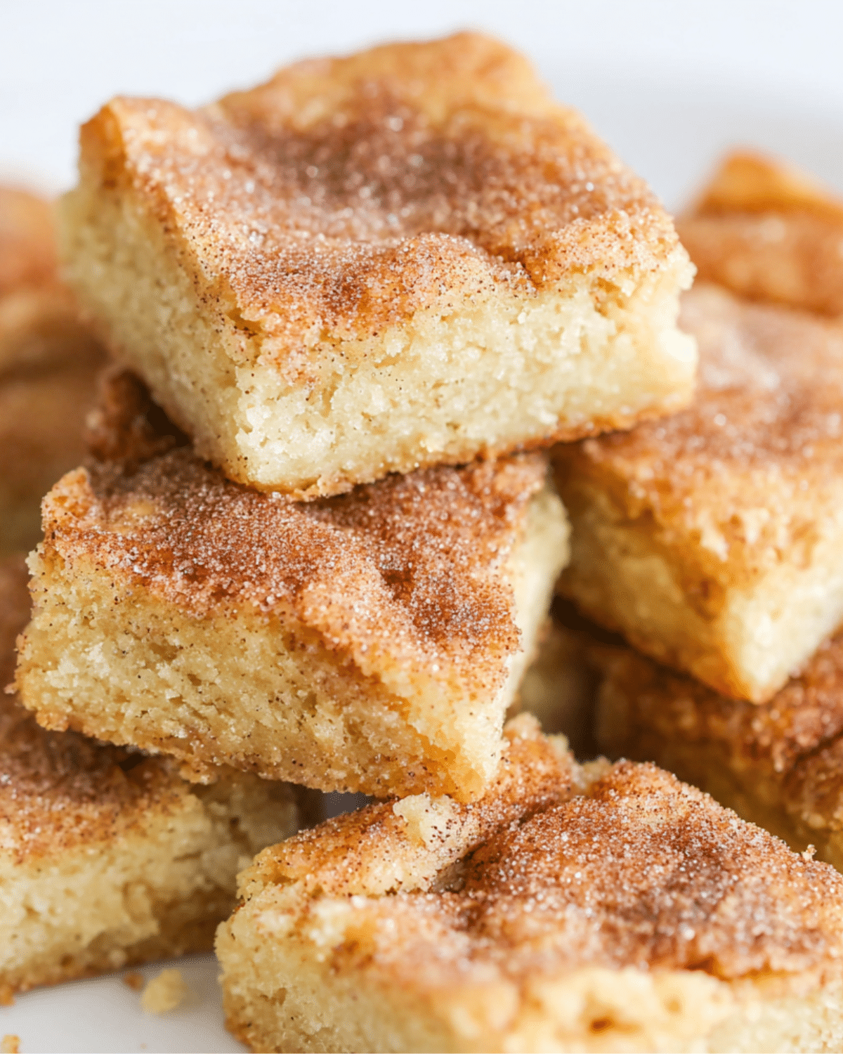 A stack of soft and chewy cinnamon sugar blondies, topped with a golden-brown cinnamon-sugar crust.