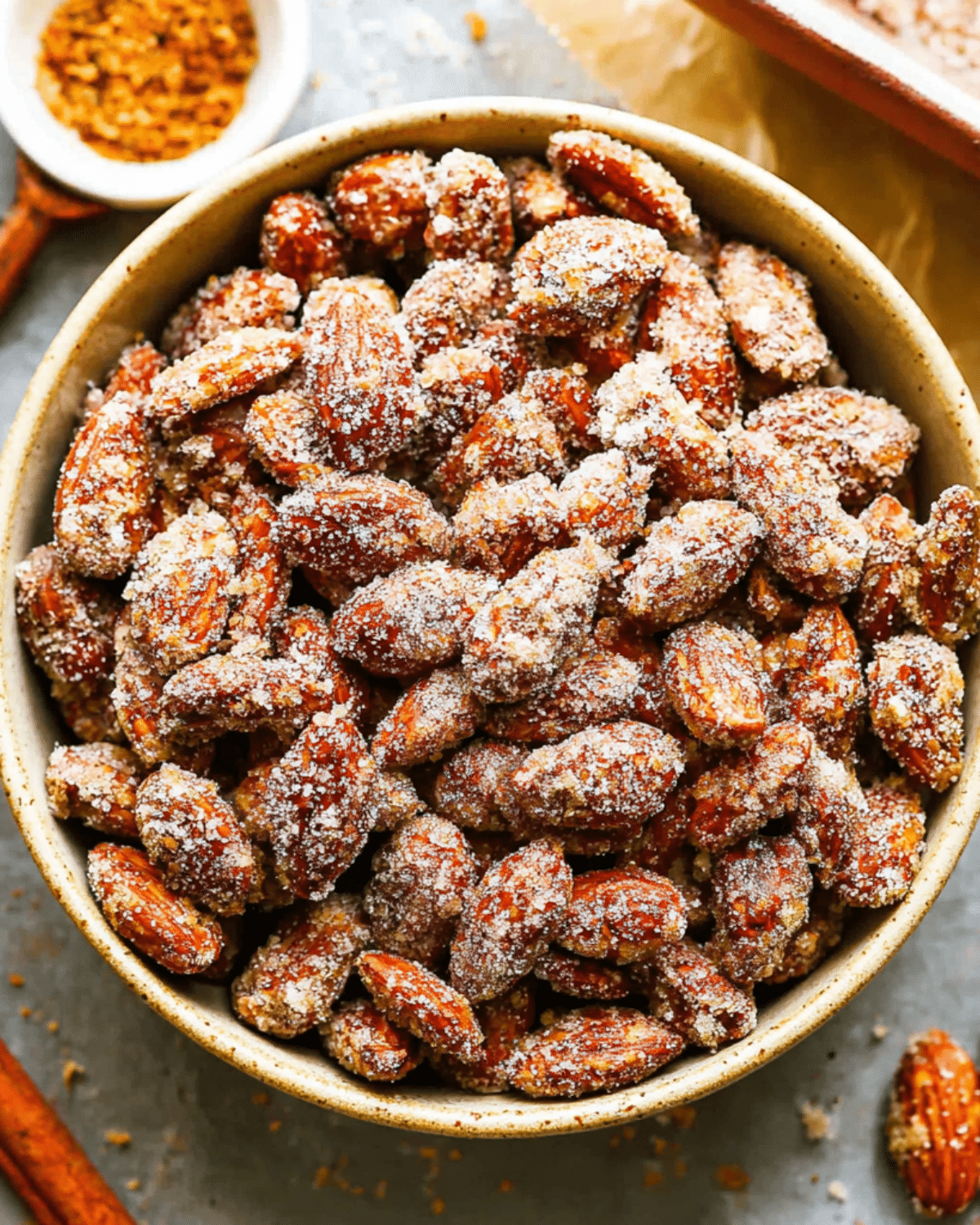 Bowl filled with crunchy Candied Almonds coated in a sugary cinnamon mixture.