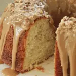 A slice of brown sugar caramel pound cake with thick caramel glaze and chopped pecans on top.