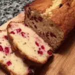 Sliced Cranberry Eggnog Bread on a wooden cutting board