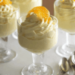 Glass dessert cups filled with creamy orange mousse and topped with orange slices