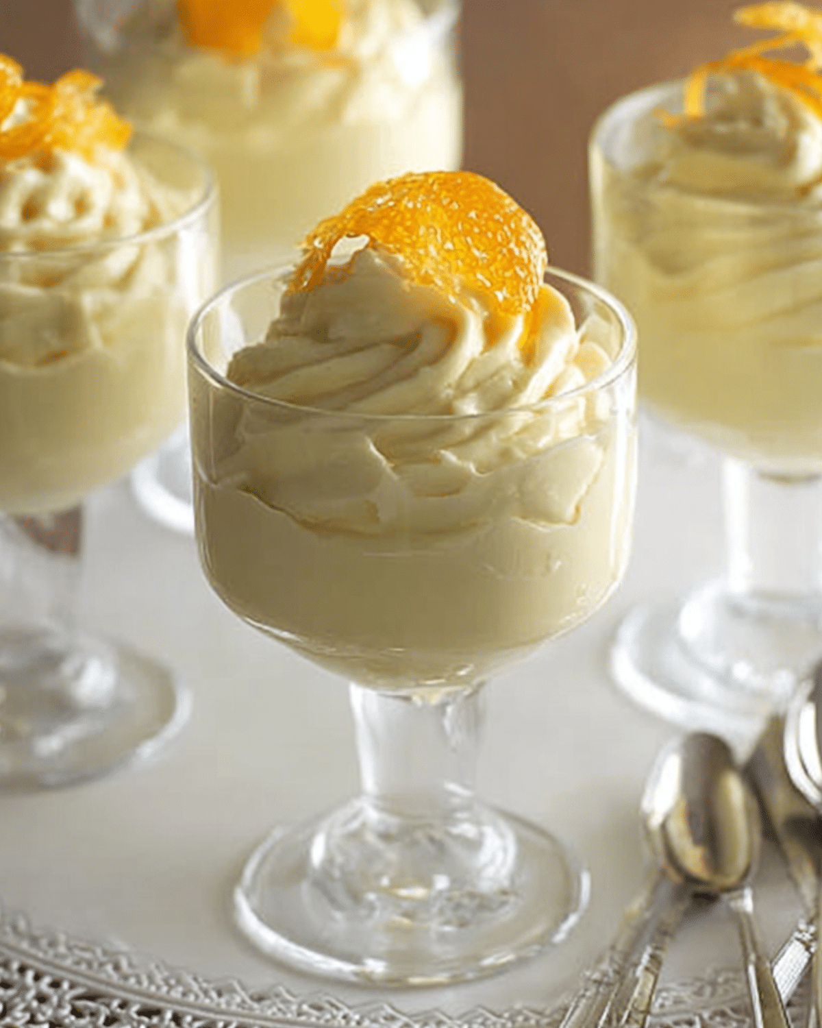 Glass dessert cups filled with creamy orange mousse and topped with orange slices