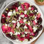 olorful pickled beet salad with goat cheese, dill, edamame, and sunflower seeds served in a white bowl.